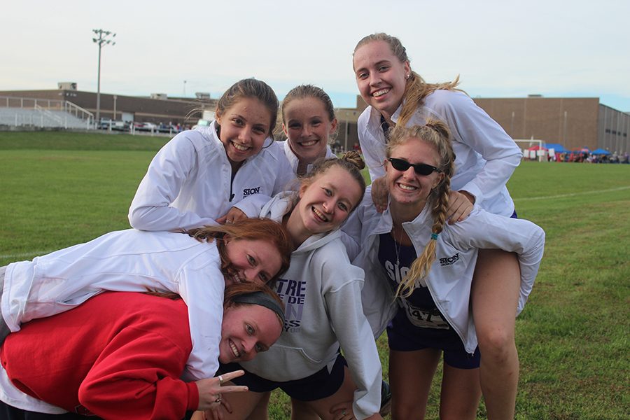 Seniors Nora Malone, Kameron Koppers, Katie Buhrmeister, sophomore Molly Conway, junior Olivia Dopheide and seniors Katia Hauptmann and Clare Kimmis hang out together after one of the last few cross country meets, the Warrensburg Invitational. 