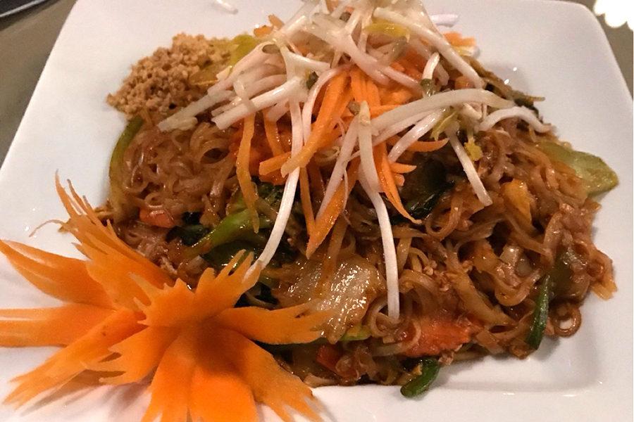 The Pad Thai dish is served with vegetables and egg noodles as well as spicy peanut sauce.