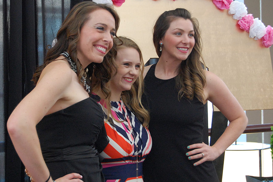 College counselor Erin Stein, junior Catherine Henne and Assistant Director of Athletics and Community Wellness Sarah Johnson pose for a photo together in front of a decorated KC sign.