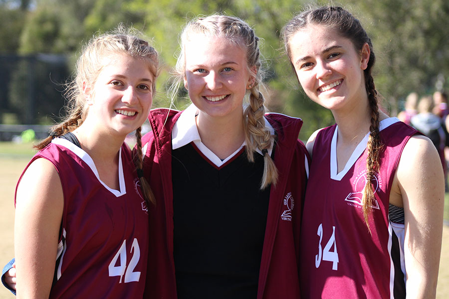 Seniors Sarah Desantis, Anna Tomka and Alisha Centrone pose for a photo after completing an all-day Australia Football League tournament. 
