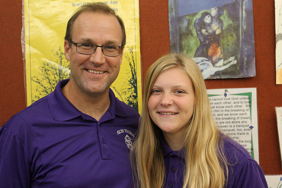 Theology teacher Paul Kramschuster and his daughter, freshman Sharon Kramschuster pose for a picture. 