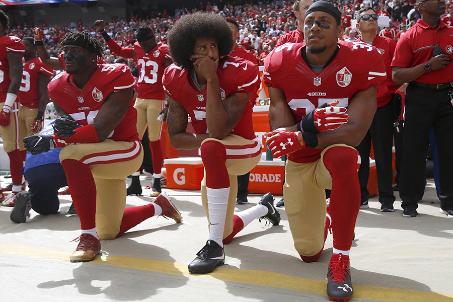 San Francisco 49ers' Eli Harold, quarterback Colin Kaepernick and Eric Reid kneel during the national anthem before their NFL game against the Dallas Cowboys Sunday, Oct. 2, 2016 in Santa Clara, Calif.