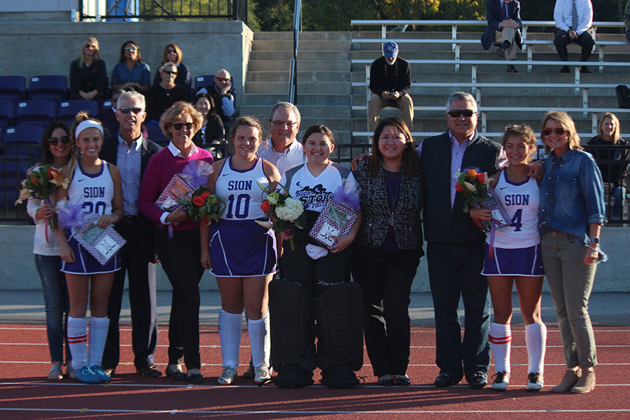 Seniors Mandy Mayer, Grace Frame, Gillian Cruz and Eden Griffith pose for a picture after receiving gifts and flowers at field hockey senior night Oct. 17.