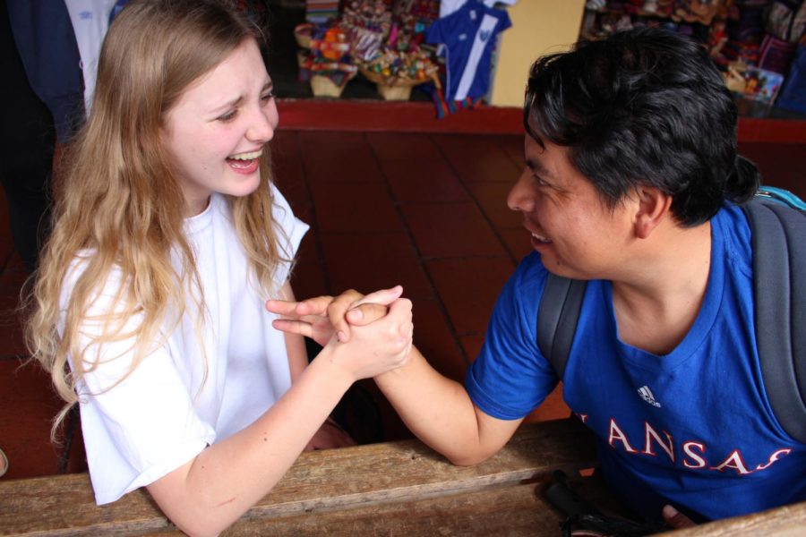 Senior Ellie Magseman and Pablo Tagual laugh while getting ready to arm wrestle in Guatemala. 