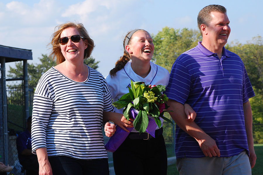 With flowers in hand, senior Sarah Schaffer laughs while her favorite memory is being read over the intercom.