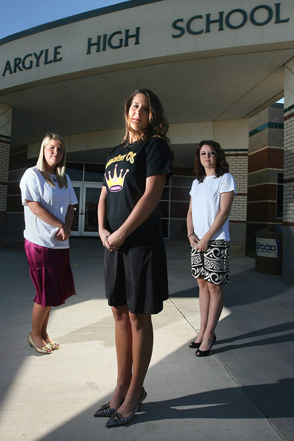 Argyle High School seniors Meghan Donnelly, Alyssa Creager and Laura Carr  pose with t-shirts over their dresses which didn't meet the dress code for a recent homecoming dance. 