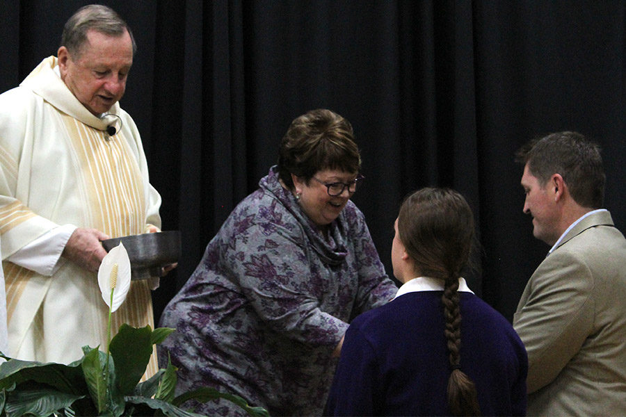 Sophomore Kaitlin Lyman and her Father, Ed Lyman, present the gifts to Theology teacher Bonnie Haghirian and Father Jerry Warris.