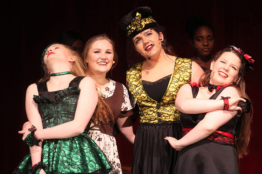 Junior Elizabeth Ericson, playing Grace, sophomores Avery Kuhls and Maya Bair, playing Cinderella and the step mother, and junior Tess Prusa, playing Joy, hold hands while singing and remembering the night before during the musical “Cinderella,” performed Jan. 19-21.