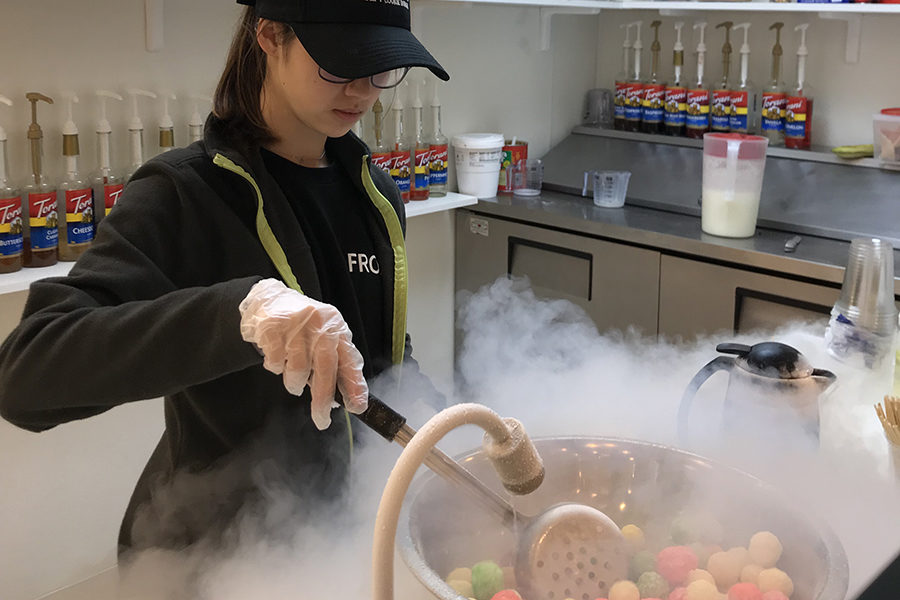 A FrozeN2 Cafe worker mixes the dragon breath dessert with the liquid nitrogen.