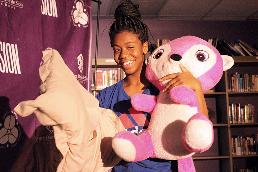 Freshman Kyra Wilburn walks down the runway in the library holding a pillow and stuffed animal as a part of her outfit April 25.