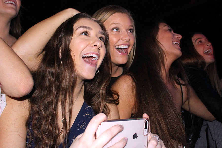 While the senior dads serenade their daughters, seniors Kathleen Tushaus and Allie Weinrich laugh and record the performance of “Sweet Caroline.” The lyrics were changed to fit the perspective of the fathers’ nostalgia of their girls graduating soon.