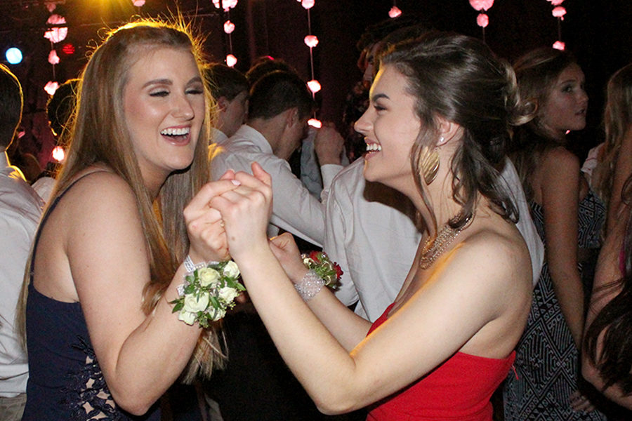 While laughing, seniors Stella Lilek and Tierney Manning dance together at Prom April 7, 2018. The theme for Prom was “In Bloom” which was inspired by Gucci Mane’s latest collection. This year's prom is Mar. 28. The theme is "Fire and Ice."