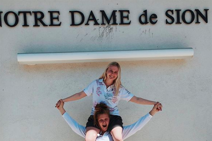 Seniors Anna Tomka and Ella Anstoetter take pictures to celebrate their last day in uniform. 