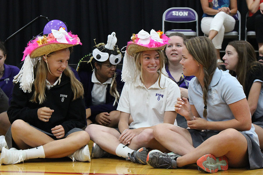 Senior Liz Oltjen introduces herself to freshmen Samantha Phillips and Tess Tappan after presenting them with their beanies at the beanie presentation Aug. 27. 