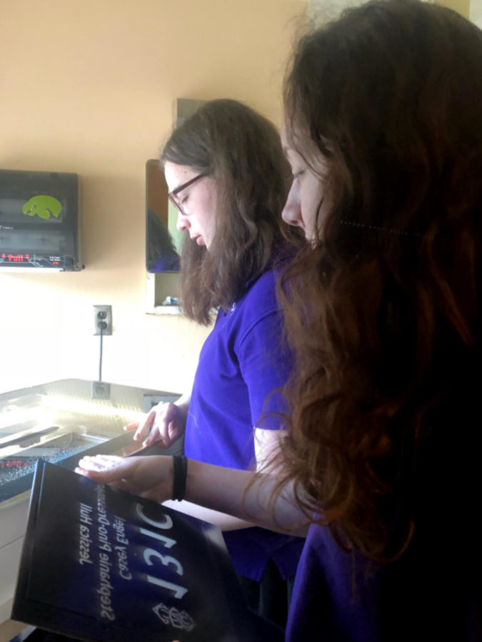 Seniors Katie Rosasco and Sam Wilson create the new room signs with the Robotic's laser cutter.