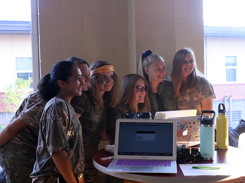 Sophomores Megan Adalco, Olivia Shively, Sophia Allen, Madeline Hammett, Haley Langle and Sharon Kramschuster pose for a picture for Campus Ministry Director Stephanie Pino-Dressman before school Sept. 18. The spirit week theme for the day was camo.