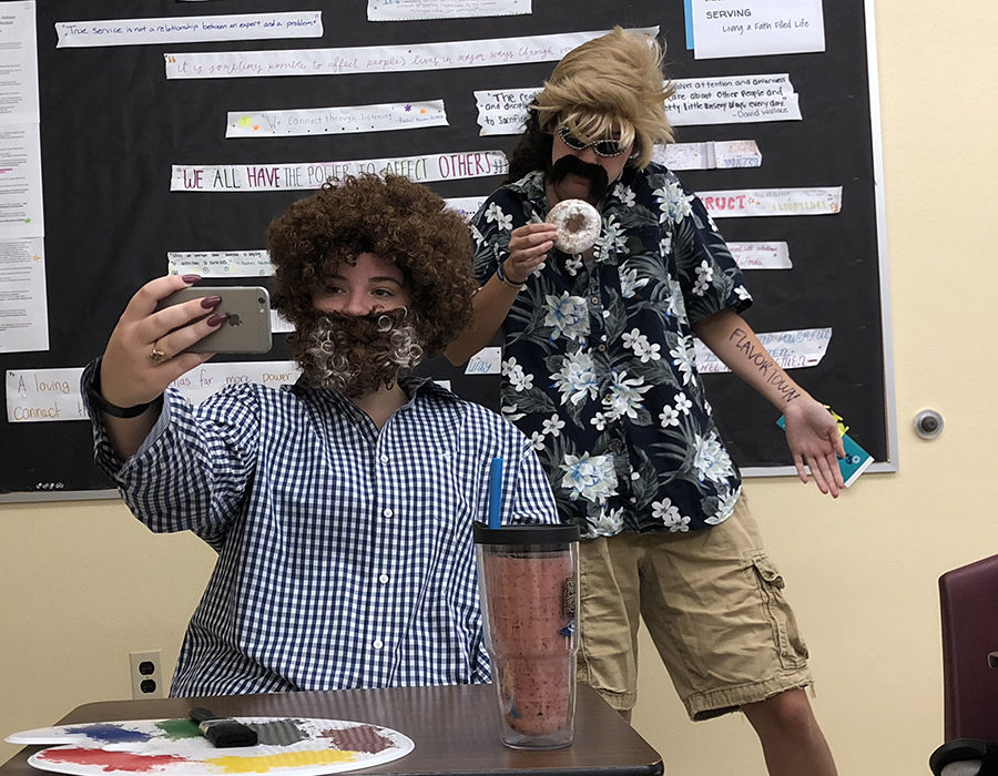 Dressed as artist Bob Ross and chef Guy Fieri, seniors Emma Cruciani and Suki Arnold pose for a selfie in Psychology class Sept. 20. The spirit theme of the day was celebrity couples.