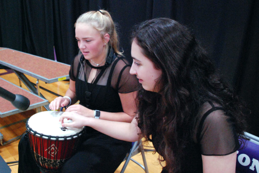 Sophomore Grace Steyer gets help from junior Ceresa Munjak-Khoury on the rhythm before their performance at Her Majesty’s Theater Oct. 15. The theme for the night was community. 