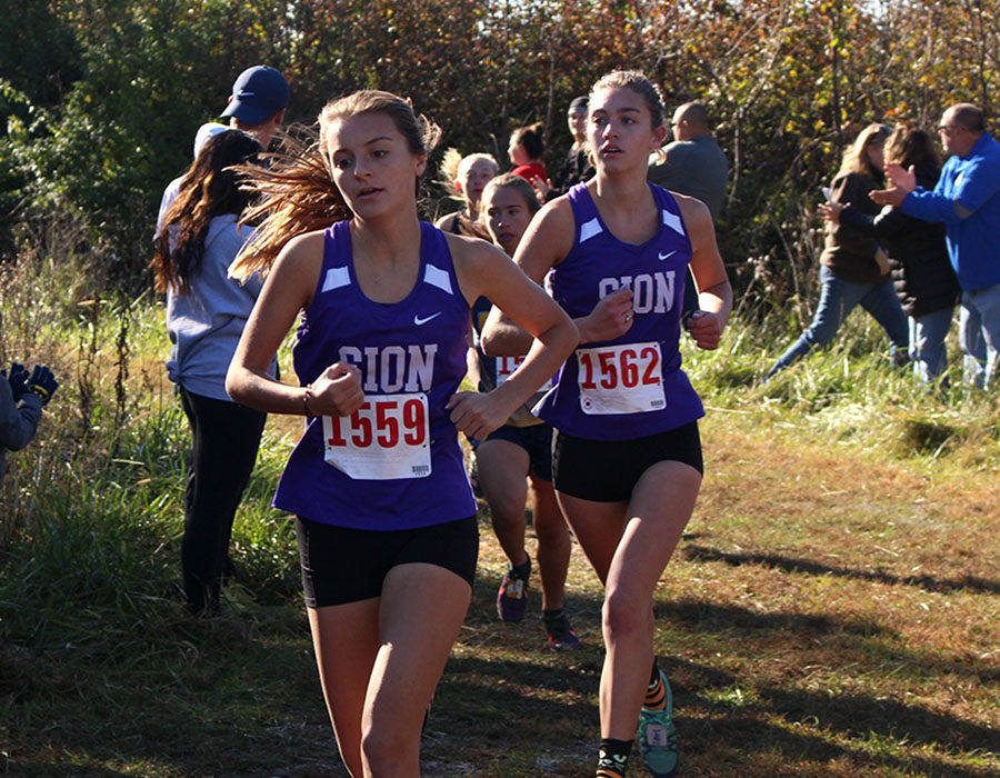 Senior Rose Orrick and alumna Brenna Richart '19 cross the one mile mark at the District cross country meet in Lake Jacomo Oct. 20, 2018. Orrick placed 35th and Richart placed 29th and will continue onto the sectional competition.