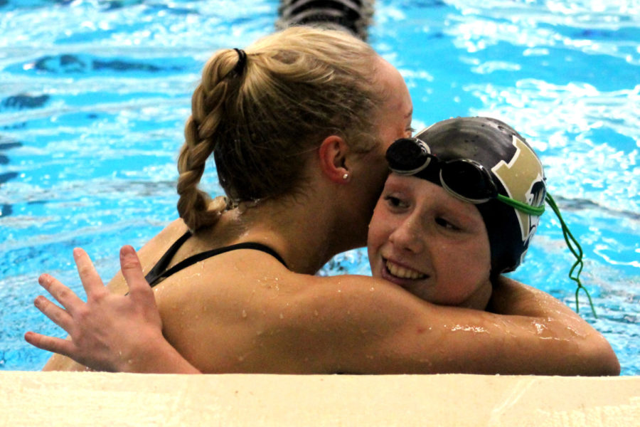 After qualifying for state in the 100-yard breaststroke, junior Olivia Townsend hugs Lee's Summit freshman Olivia Strikeleather who also qualified at the meet at Lee’s Summit Aquatic Center Dec. 11.