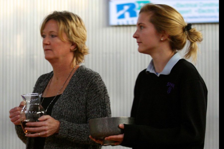 Senior Kelsey Wilcoxson and her mother Kris Wilcoxson bring up the gifts at the Mass Dec. 5. 