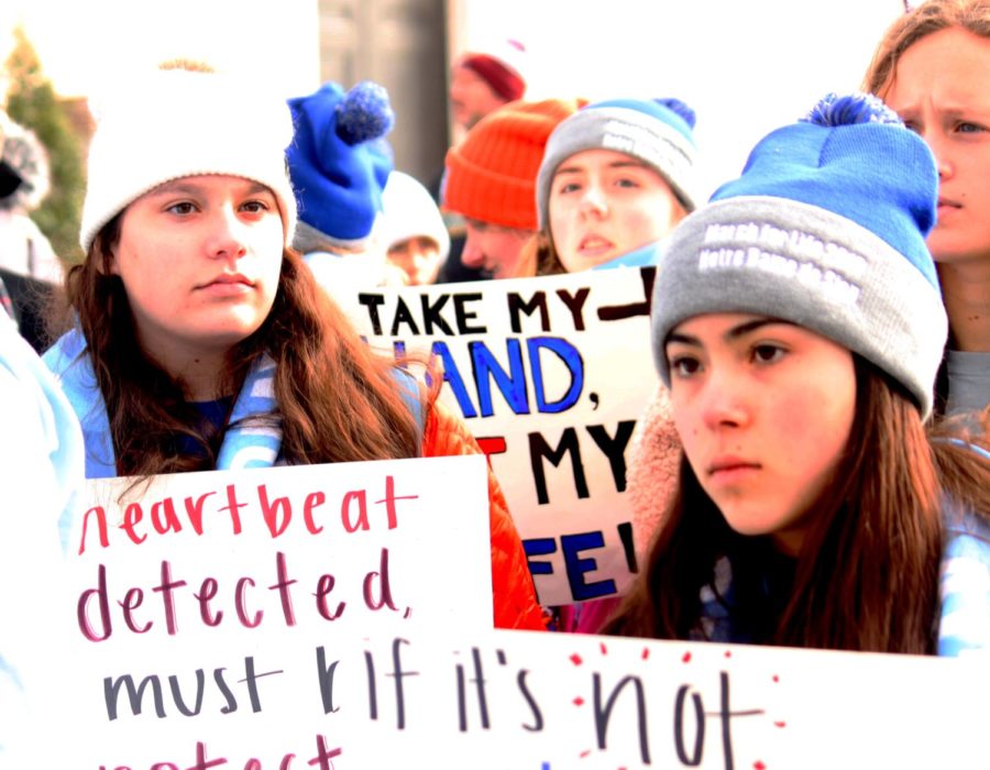 During the March for Life in Washington D.C. Jan. 18, sophomore Morgan Herriott and freshmen Lydia Poe and Sofia Aguayo carry homeade signs as they marched. The students made the signs in their hotel room the night before.