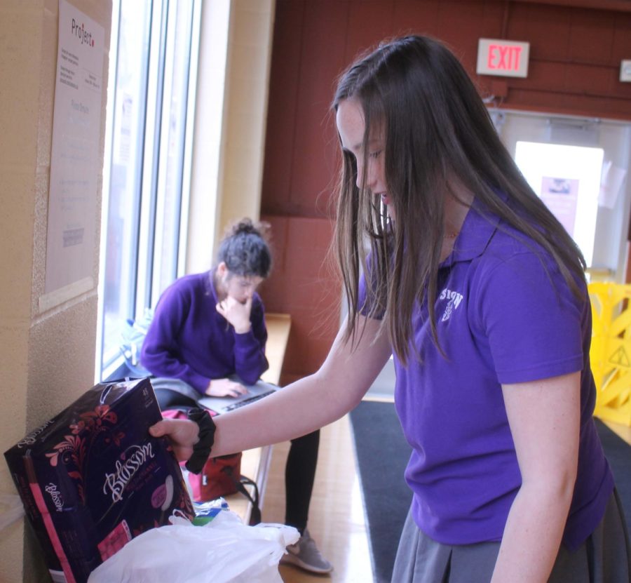 Sophomore Mason Lewis places pads in the collection box for Project Period Jan. 29. Purple maisons are supposed to drop off in the commons and white maisons in the Grande Salle.