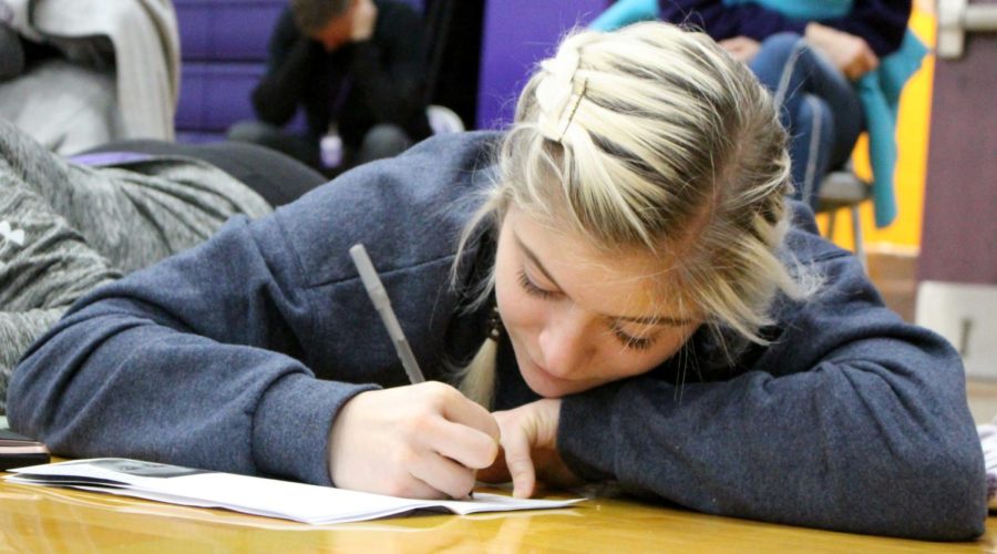 Senior Isabelle Ianni reflects on the documentary, Girl Rising, during the feast day celebration Jan. 16 in the gym. Students were given booklets with reflection questions to help guide them as they watched. 