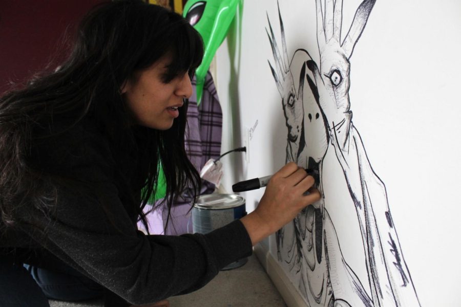 Senior Safa Khan works on her most recent addition to her collection of drawings on her wall, a character from Pan’s Labyrinth.