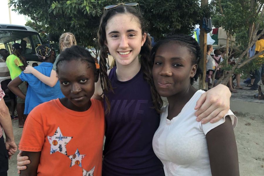 Sophmore Grace Hill hugs her new friends she has made while in Haiti volunteering with the Global Orphan Project.