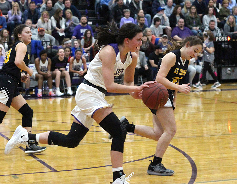 Sophomore Shannon Karlin rushes the ball down the court in the final seconds of the third quarter during the basketball game versus St. Teresa’s Academy Feb. 21. The team fell to the Stars 61 to 55.