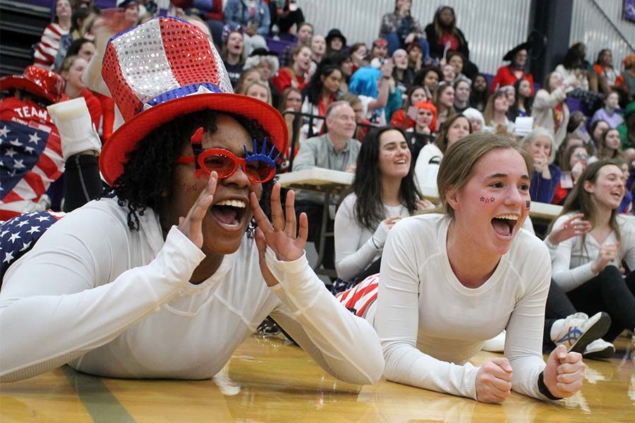 Seniors Kendall Rogers and Gabby Grimaldi cheer on seniors Lola Tebbe and Savannah Childress participating in a game of blindfolded musical chairs during Sion Olympics March 7. Junior Peyton Wiewel ended up winning the game.