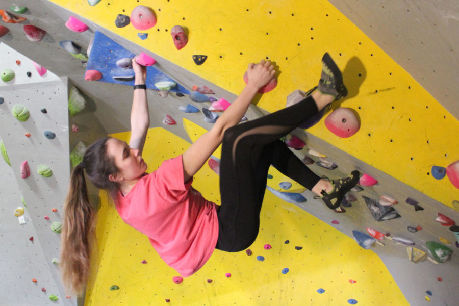 Senior Savana Mayer climbs a route in the cave area of the gym.