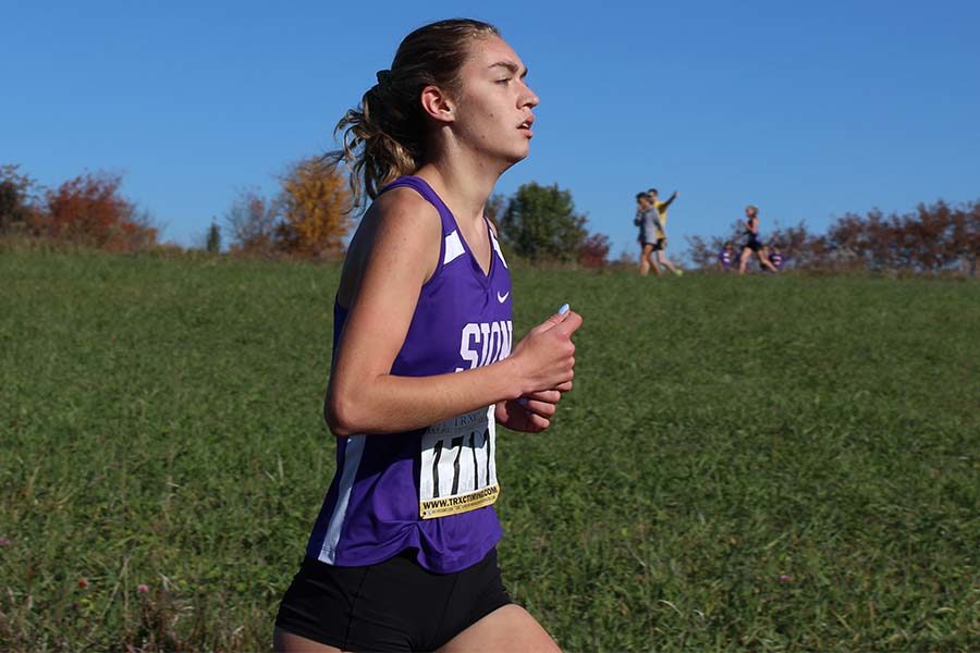 Senior Brenna Richart crosses the one mile marker at the Sunflower Cross Country Course in Liberty Oct. 27.