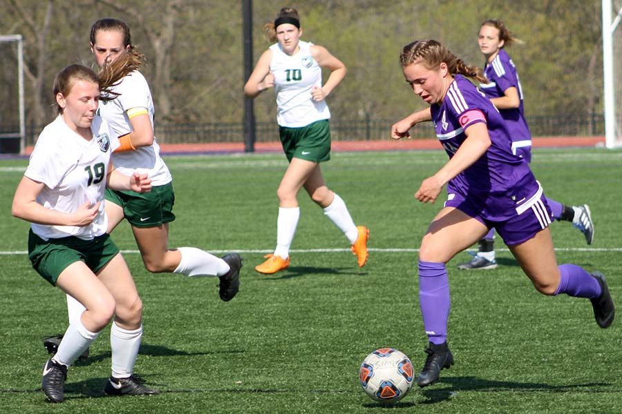 Running down the field, senior captain Gabby Grimaldi dodges players from Lafayette High School on the night of the Freshmen Welcome April 16.