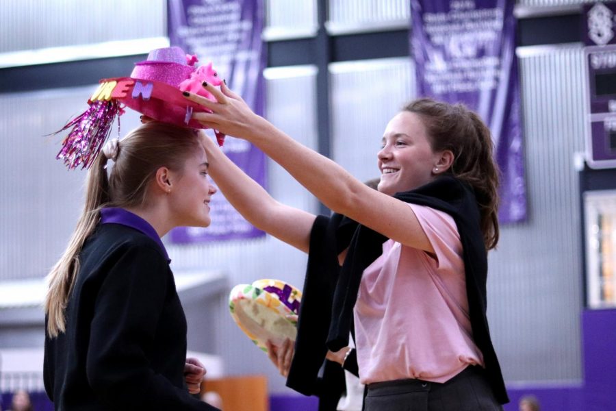 Senior Brooke McKee arranges a gleaming pink top hat on freshman Lauren Smith.