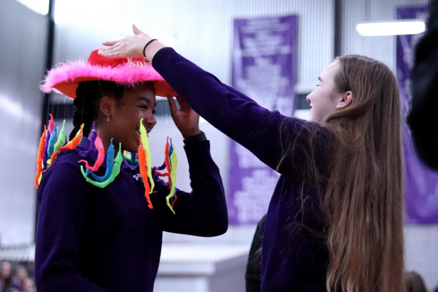 Senior Peyton Wade positions the fur-lined beanie complete with squiggly worms dangling on freshman Kori Franklin’s head.