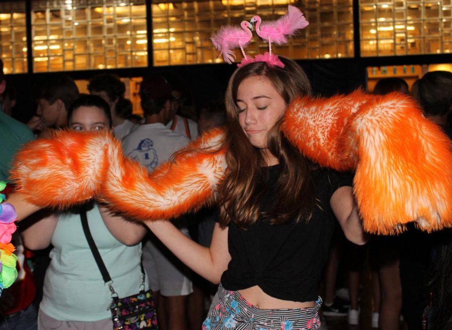 St. Teresa's freshman Keely Spencer dons senior Reilly Jackoboice's light up sweater and flamingo headband during the mixer. 