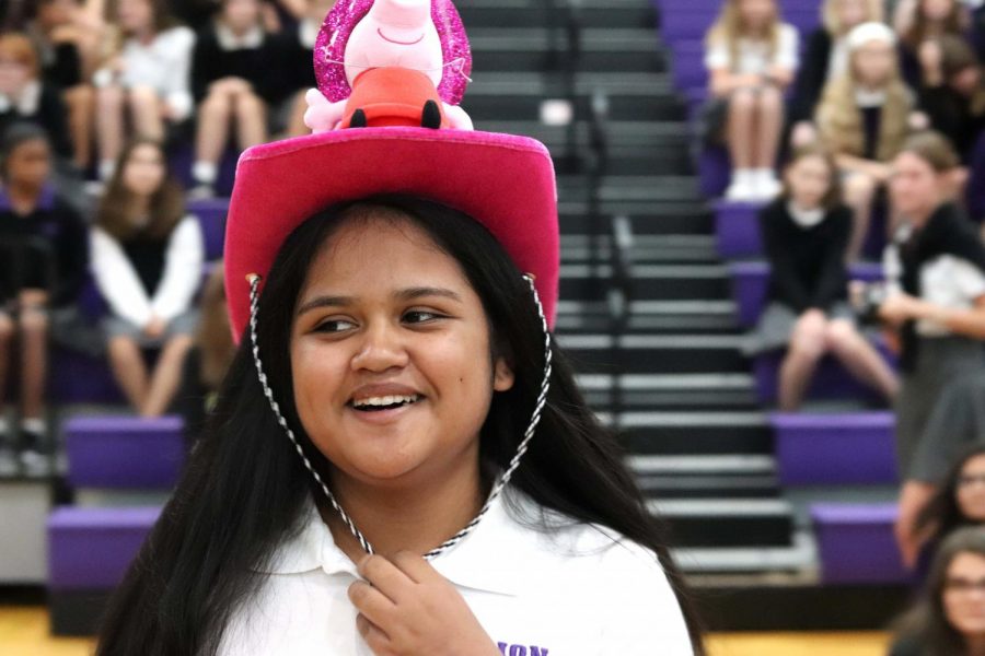 Freshman Juwali Ya strolls to the side of the gym in her new Peppa Pig hat during the Beanie presentation Aug. 22.