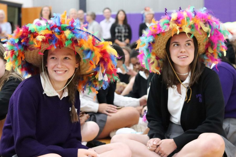 Sitting in eager anticipation for the beanie ceremony, seniors Erika Sesler and Sophia Angrisano sport the beanies they made for the freshmen in their maison. To pay homage, Sesler and Angrisano modeled their beanies after the ones they received freshman year.