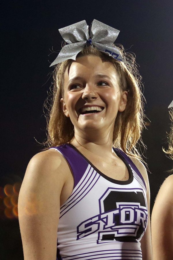 Senior Brooke McKee looks over at the students cheering for her from the stands. This was Mckee’s last year performing with cheer at the Rockhurst football game during halftime Sept. 13.