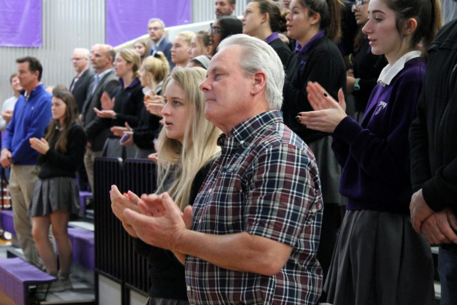 Senior Madi Brown and her father Kevin Brown join in the school song at the Father-Daughter Mass Nov. 1.