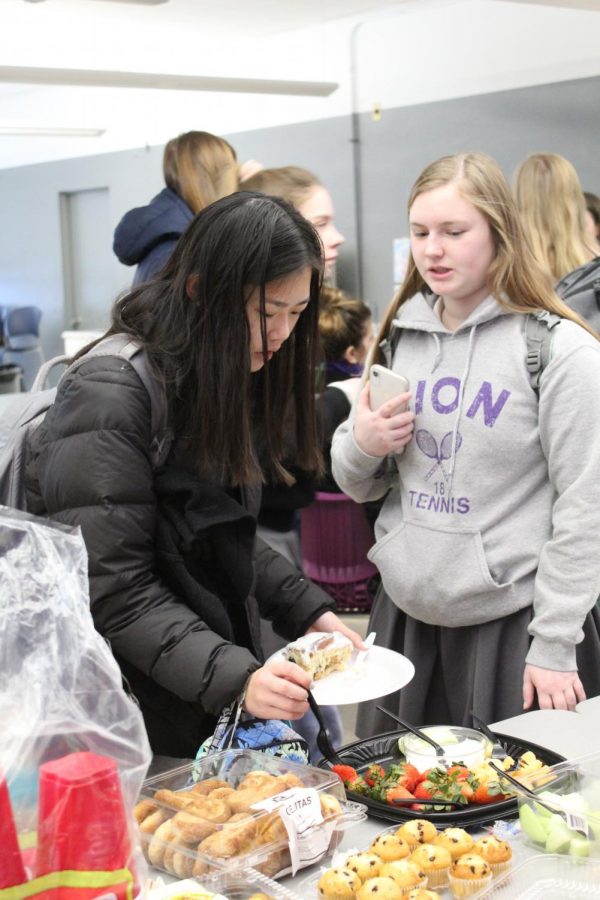 Junior Lia Concannon joined with junior Katherine Lillis at the buffet for fruit at the Spanish club breakfast Jan. 22.