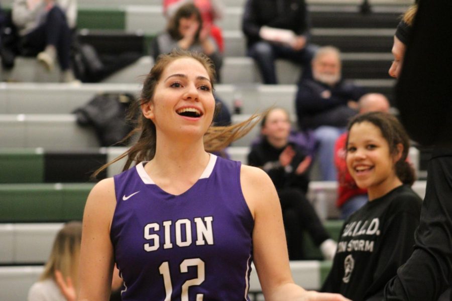 Junior Gabby Gaither flashes a smile to teammate sophomore Anna Sheedy as her name is called as a starter for the game against Blue Valley Southwest Feb. 5. Storm lost 67-55 to the Timberwolves.