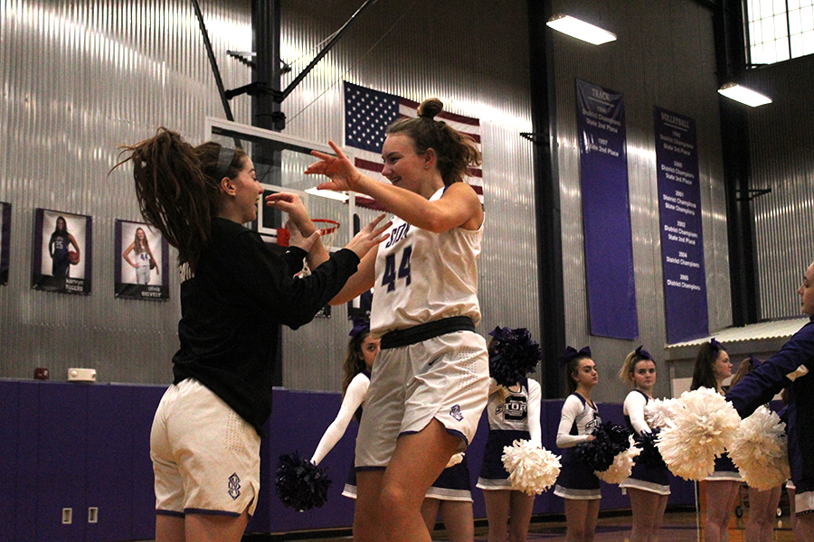 Juniors Gabby Gaither and Olivia Shively high five before the game. Varsity won 47-13 against Metro Academy Feb. 12. 