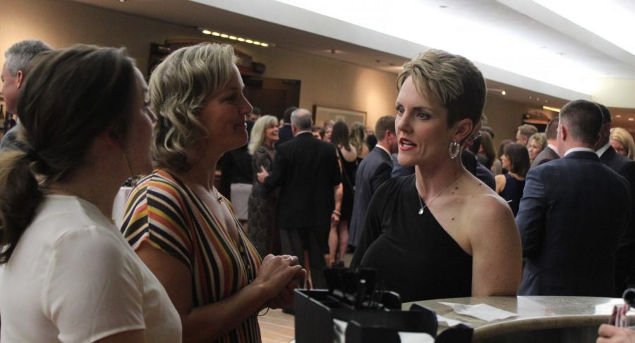 Alumna Christy Shively '95 and friend Kristin Hammett, mother of junior Madeline Hammett, discuss their daughters' Sion experience while waiting in line for the free bar. 