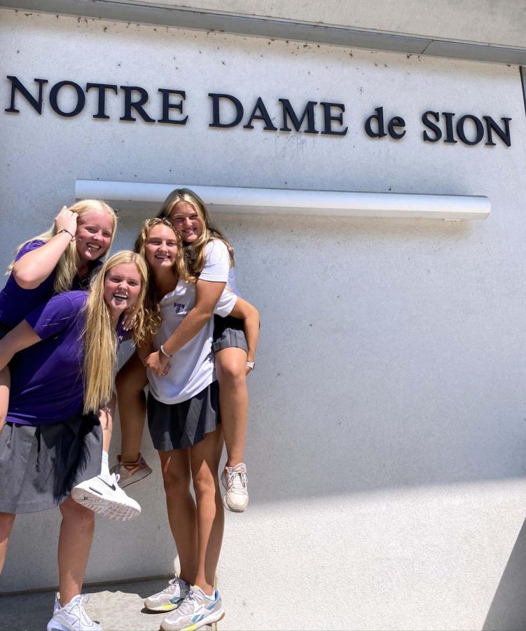 Senior Madeline Hammett and Senior Olivia Shively hold freshman sisters Caroline Hammett and Lucy Shively after the first day of school on Aug. 25. 