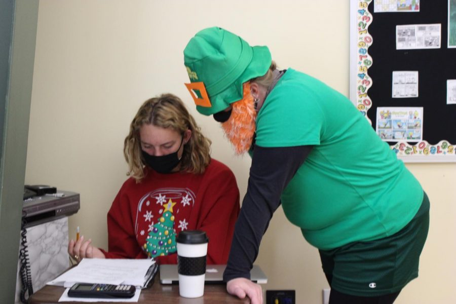 Math teacher Kristin Hilgenfeld, dressed up as a leprechaun, helps senior Olivia Shively with her math questions on Oct. 2. 
