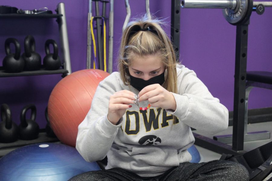 Senior Averi Myrick makes a bracelet with her maison while reflecting on the Interfaith Prayer Service Jan. 21.