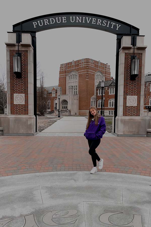 Junior Kate McCarthy takes a picture in front of the gates at Purdue University on her various college tours over spring break. 